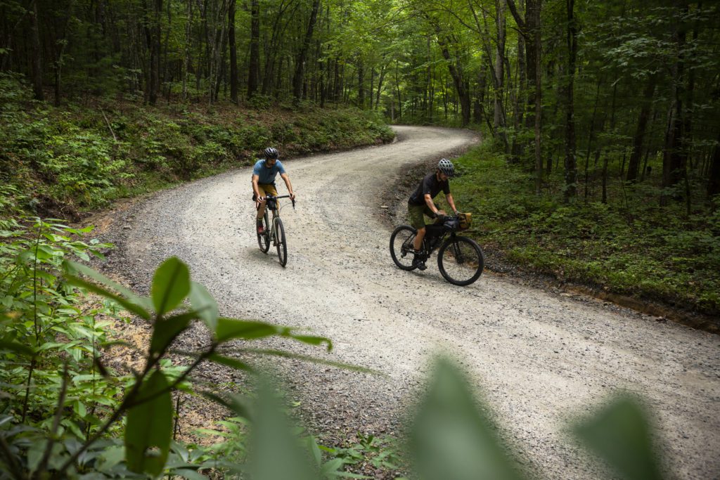 two cyclists climbing up a gravel road